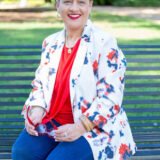 Kimberly McGhee smiling and sitting on a park bench