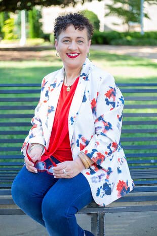 Kimberly McGhee Kimberly McGhee smiling and sitting on a park bench
