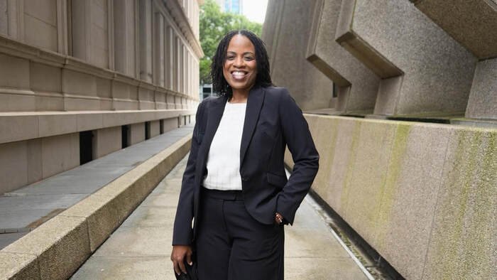 Sherita Walton standing and smiling in between buildings.