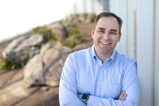 Wiley Nickel Wiley Nickel smiling and leaning against a wall outside.